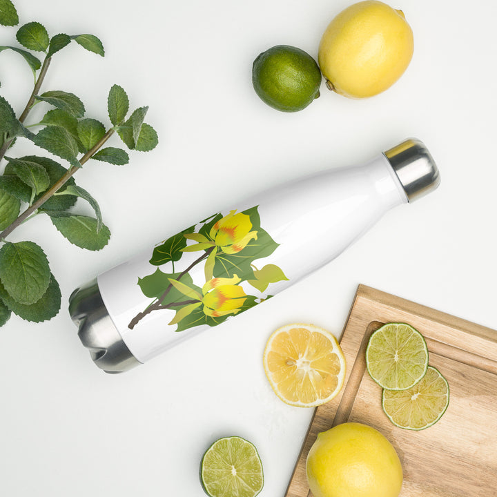White stainless steel water bottle with a tulip poplar motif in yellow and green resting on its side on a counter among lemons and limes